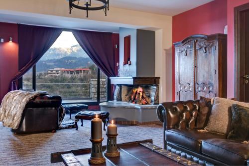a living room with a couch and a fireplace at Volhon Mansions of Parnassos in Eptalofos