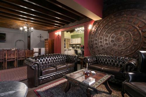 a living room with leather couches and a table at Volhon Mansions of Parnassos in Eptalofos