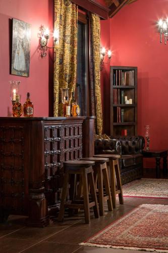 a living room with red walls and a table and stool at Volhon Mansions of Parnassos in Eptalofos