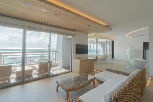 ein Wohnzimmer mit einem weißen Sofa und einem großen Fenster in der Unterkunft THIRD ishigakijima in Ishigaki-jima