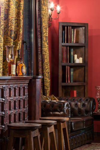 a living room with a leather couch and a book shelf at Volhon Mansions of Parnassos in Eptalofos