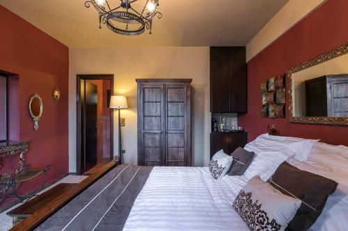 a bedroom with a large bed with red walls at Volhon Mansions of Parnassos in Eptalofos
