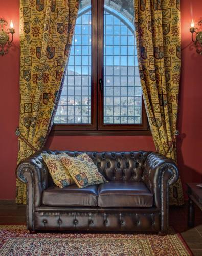 a leather couch sitting in front of a window at Volhon Mansions of Parnassos in Eptalofos
