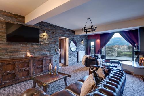 a living room with a couch and a tv at Volhon Mansions of Parnassos in Eptalofos