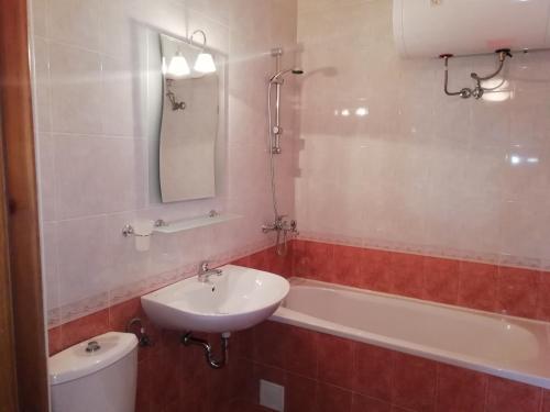 a bathroom with a sink and a tub and a toilet at Apart Hotel Efir in Sunny Beach