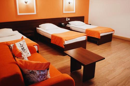 Cette chambre comprend deux lits, une table et une chaise. dans l'établissement Kosmos Hotel, à Yaroslavl