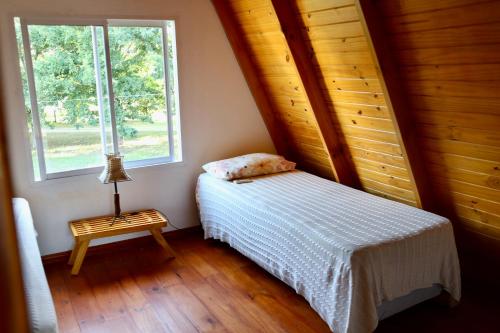 a small bedroom with a bed and a window at LAS ALPINAS in Gualeguay