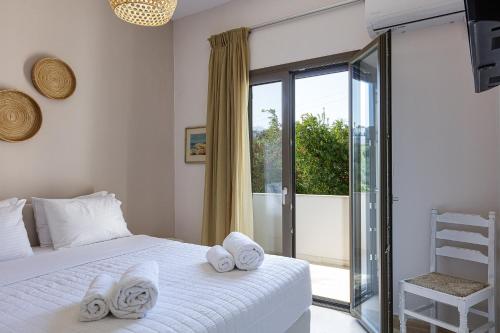 a bedroom with a bed and a sliding glass door at Mithonies Villa, with Private Pool & BBQ, By ThinkVilla in Margarítai