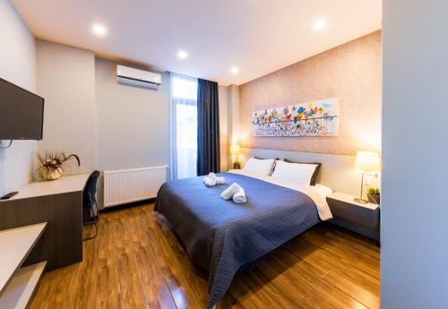 a hotel room with a bed with two stuffed animals on it at Sani Apart Hotel in Tbilisi City