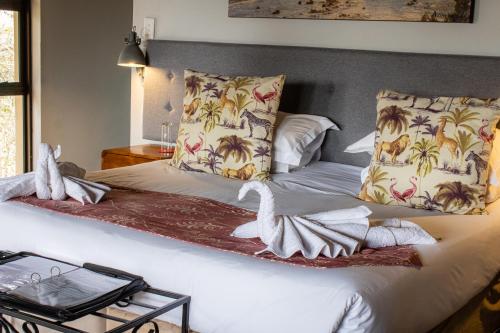 a bedroom with a bed with two swans on it at Tshikwalo Game Lodge in Klipdrift