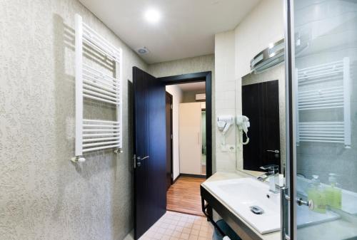 a bathroom with a sink and a glass shower at Sani Apart Hotel in Tbilisi City
