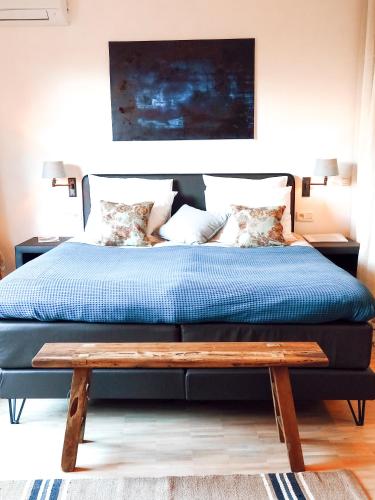 a bed with a wooden bench in a bedroom at B&B Tholen t’Uusje in Tholen