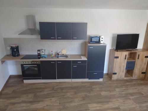 a kitchen with black cabinets and a sink at Ferienwohnungen Kay in Kirchaich
