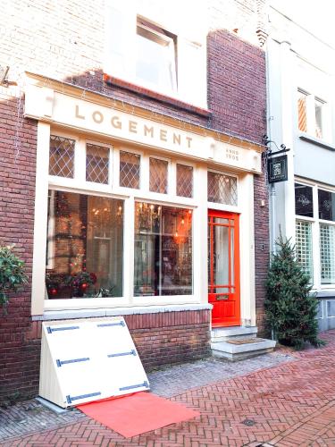 a store with a red sign in front of a building at B&B Tholen t’Uusje in Tholen