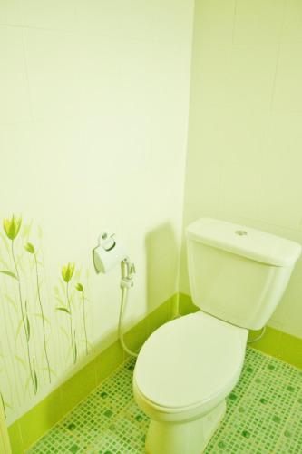 a white toilet in a bathroom with a shower at Suandarbporn Resort Mae Sot in Mae Sot