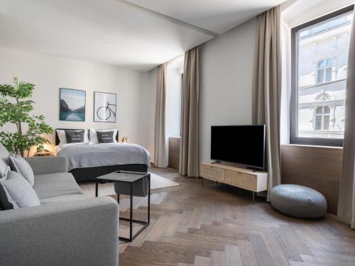 a bedroom with a bed and a tv and a couch at Limehome Linz Schillerstraße in Linz