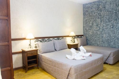 a bedroom with two white swans sitting on a bed at Pousada Brasil Nativo in Cabo Frio