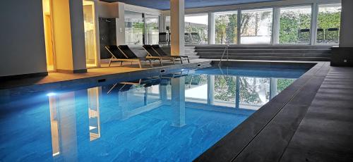 ein großer Pool mit Stühlen in einem Gebäude in der Unterkunft Studio Fumzi in Ascona