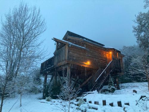 une cabane en rondins dans la neige éclairée dans l'établissement Le chalet du Pibeste, à Agos-Vidalos
