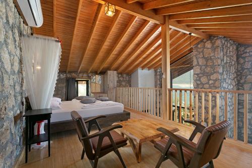 um quarto com uma cama, uma mesa e cadeiras em Botanik Göl Evleri em Bucak