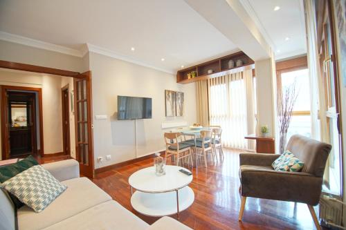 een woonkamer met een bank en een tafel bij Piso Grande y Luminoso en el Casco Viejo de Bilbao in Bilbao