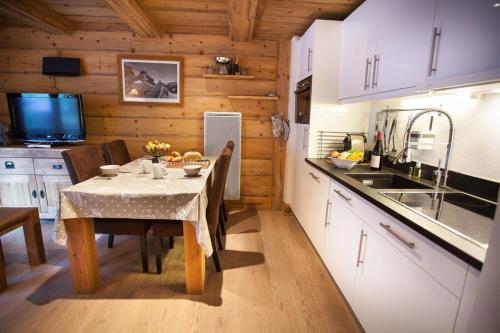 a kitchen with a table and a dining room at Apartment Blaitiere - luxurious 2 bed apartment in Chamonix