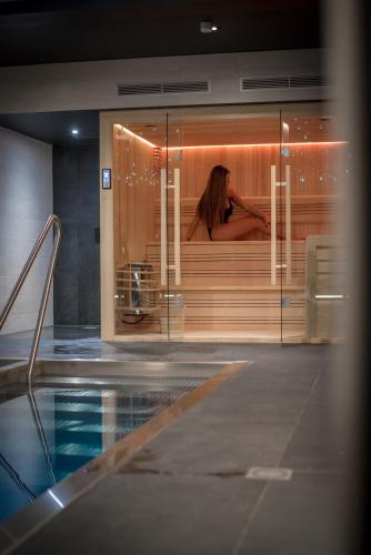 a woman in a bath tub in a swimming pool at L' Hôtel & Spa Ribeauville- Haut-Koenigsbourg in Ribeauvillé