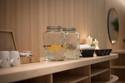 two mason jars sitting on a counter in a room at L' Hôtel & Spa Ribeauville- Haut-Koenigsbourg in Ribeauvillé