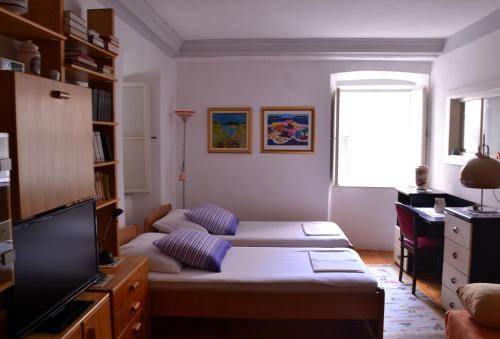 uma sala de estar com duas camas e uma televisão em Apartment Divina Ragusa em Dubrovnik