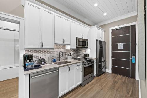 a kitchen with white cabinets and stainless steel appliances at Anna Maria Beach Resort in Holmes Beach