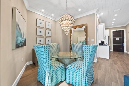 a dining room with a glass table and blue chairs at Anna Maria Beach Resort in Holmes Beach