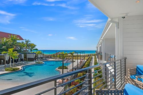 a balcony with a swimming pool and the ocean at Anna Maria Beach Resort in Holmes Beach