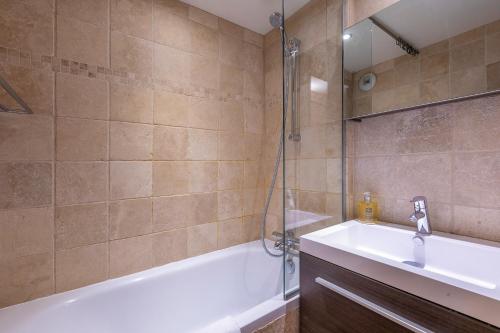 a bathroom with a tub and a sink and a shower at Val Thorens-Cosy Lauzières 315 in Val Thorens