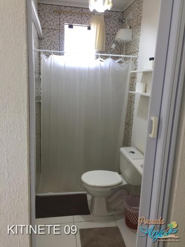 a bathroom with a toilet and a shower at Pousada Anjos - à 2 quadras do mar in Matinhos