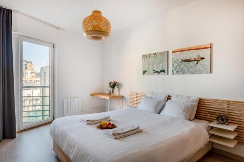 Un dormitorio blanco con una cama grande con un bol de fruta. en Royal Design Residence, en Bruselas
