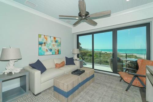 a living room with a couch and a ceiling fan at Anna Maria Beach Resort in Holmes Beach