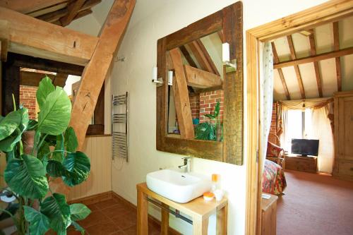 a bathroom with a sink and a mirror at Hilltop Barn in Blandford Forum