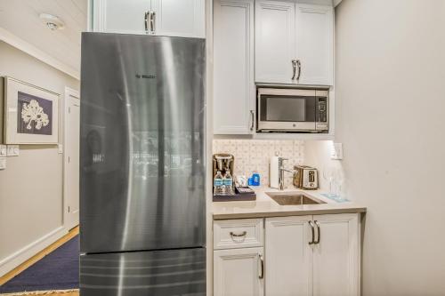 a stainless steel refrigerator in a kitchen with white cabinets at Anna Maria Beach Resort in Holmes Beach