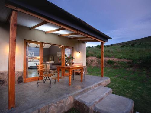 a patio of a house with a table and chairs at Berghouse and Cottages in Langkloof