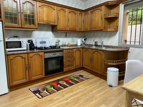 a kitchen with wooden cabinets and a kitchen rug on the floor at A casa Daló in Folgoso