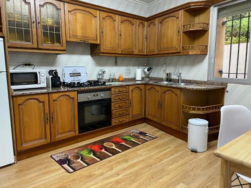una cocina con armarios de madera y una alfombra de cocina en el suelo en A casa Daló, en Folgoso