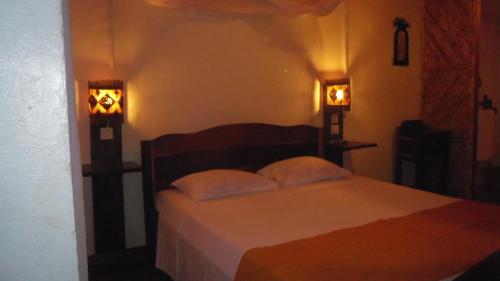 a bedroom with a bed with two lights on it at Villa Maroloko in Ifaty