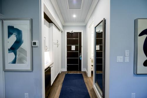 a hallway with a blue rug and a door with a mirror at Anna Maria Beach Resort in Holmes Beach