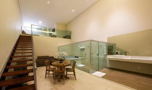une chambre avec une table et des chaises et une salle de bains. dans l'établissement Hotel Vila Verde, à Penápolis