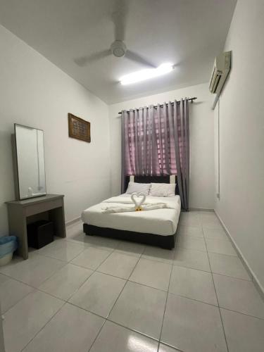 ein Schlafzimmer mit einem Bett und einem Spiegel sowie einem TV in der Unterkunft Hanz Homestay Melaka - Melayu Homestay in Malakka