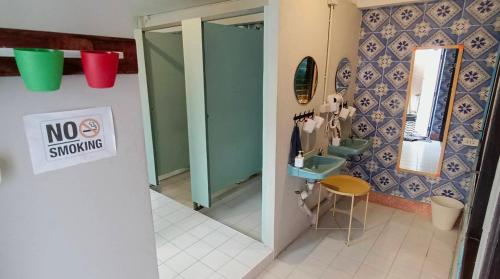 a bathroom with a no smoking sign on the wall at Sattahiptale Boutique Guesthouse & Hostel in Sattahip