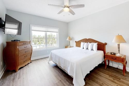 een slaapkamer met een wit bed en een raam bij Drottningholm by Meyer Vacation Rentals in Orange Beach