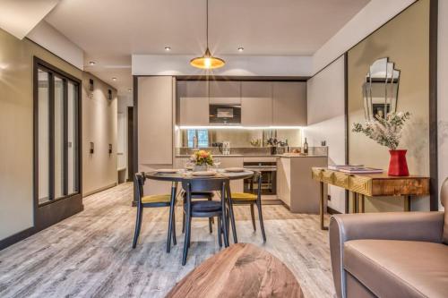 une cuisine et un salon avec une table et des chaises dans l'établissement Majestic Broadway - 4 star apartment with spectacular views, à Chamonix-Mont-Blanc