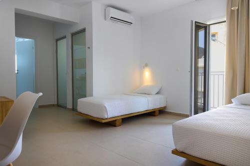 a bedroom with two beds and a table and chairs at Sea Breeze Hotel in Hersonissos