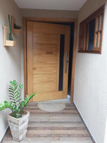una puerta de madera en una habitación con una maceta en Master Âncora, en Arraial do Cabo